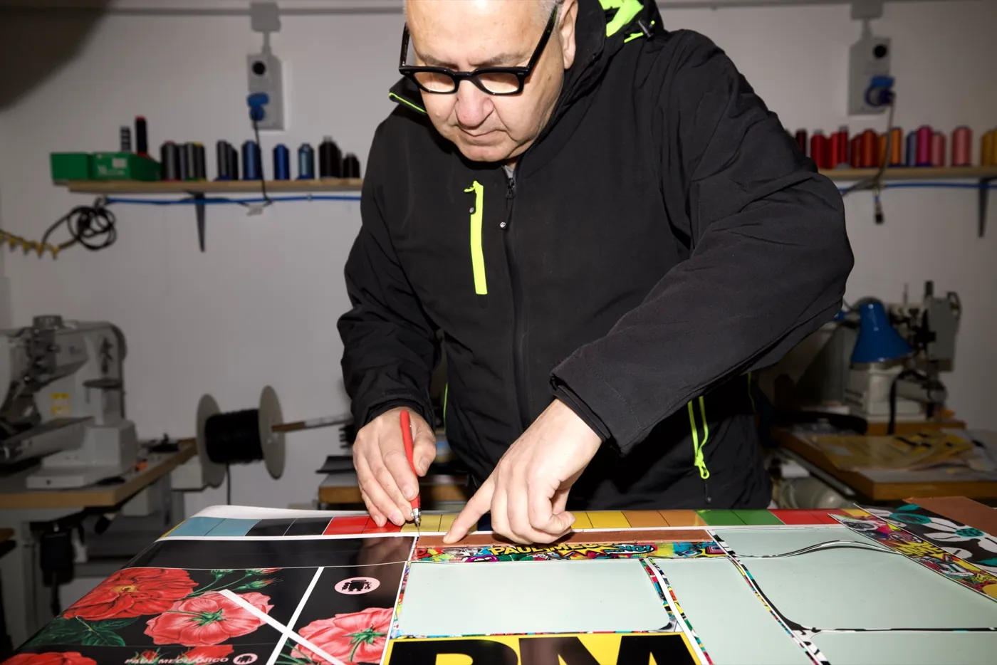 Paul trabajando en el taller de Paul Meccanico, cortando a mano material impreso
